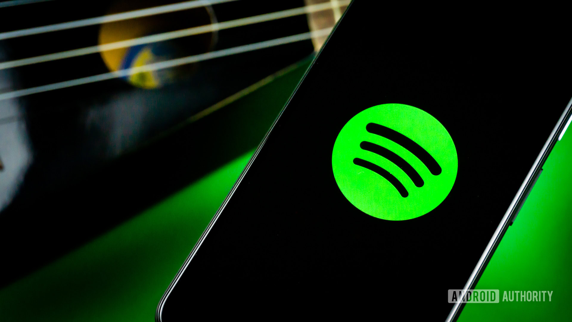 Spotify stock photo 3 Spotify on a phone next to a guitar