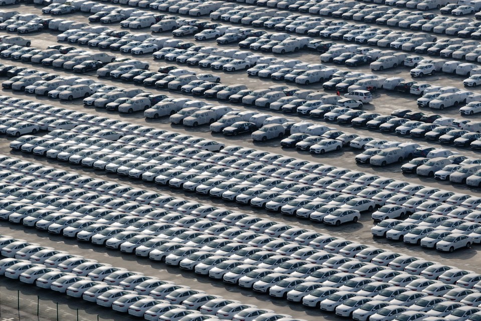 Aerial view of many cars in a port, ready for export.
