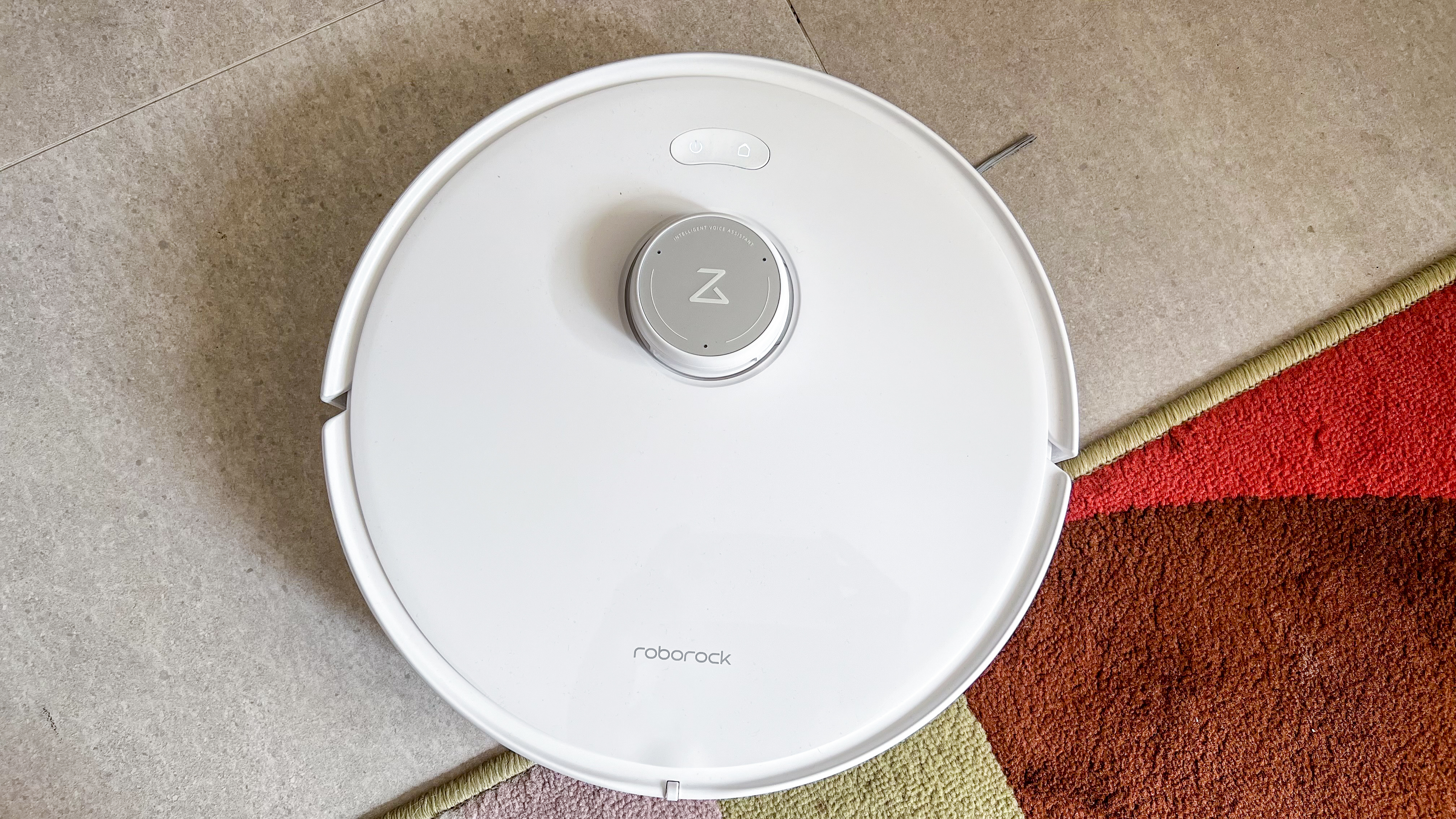 Roborock Qrevo Edge moving off a rug onto a tiled floor