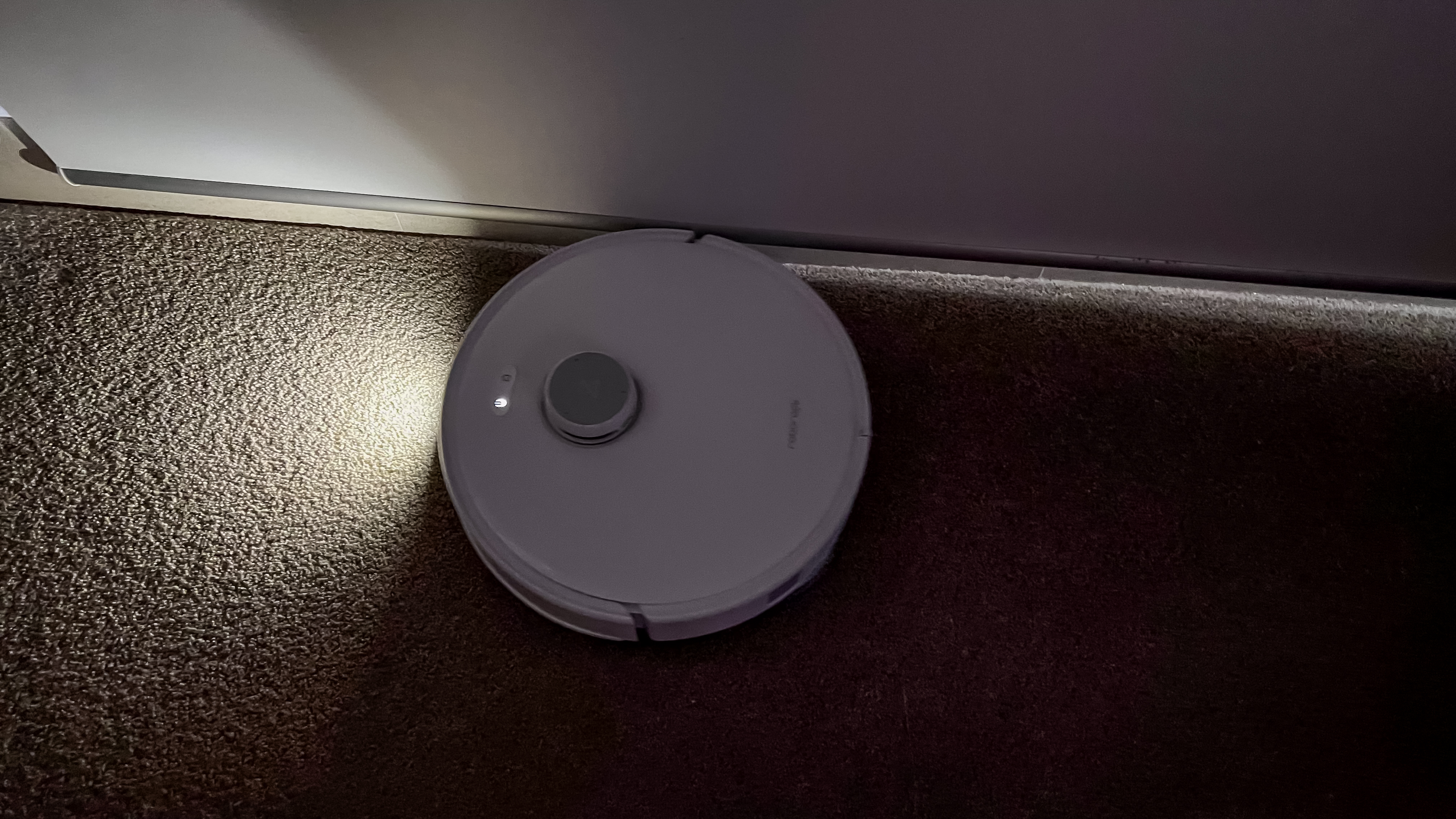 Roborock Qrevo Edge with a light on in a dark room