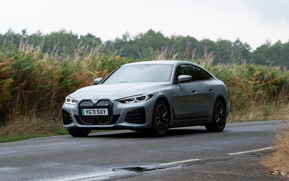 BMW i4 driving on a road.