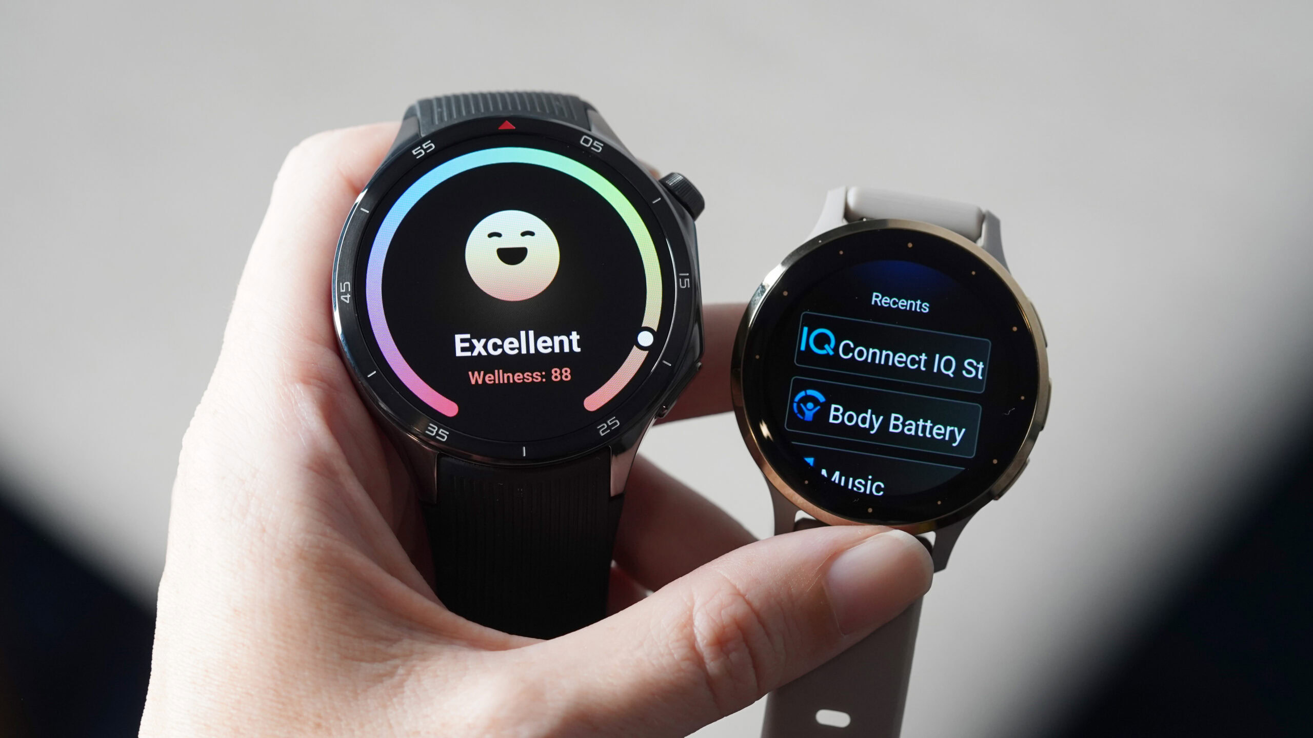 A users holds but a OnePlus Watch 3 and Venu 3 in hand. 