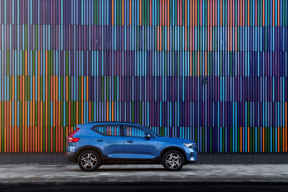 Blue Volvo XC40 B3 Plus parked in front of a colorful building.