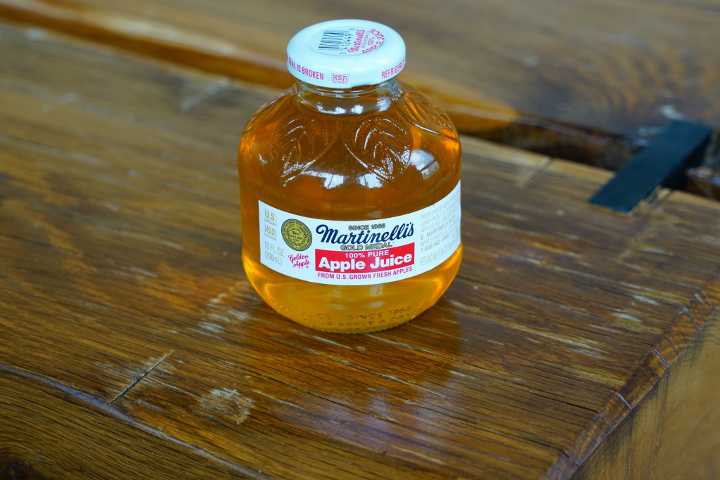 a small round glass bottle of Martinelli's Gold Medal Apple Juice.
