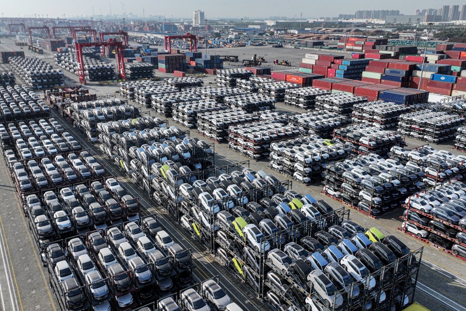 Aerial view of BYD electric cars at a port, ready for export.