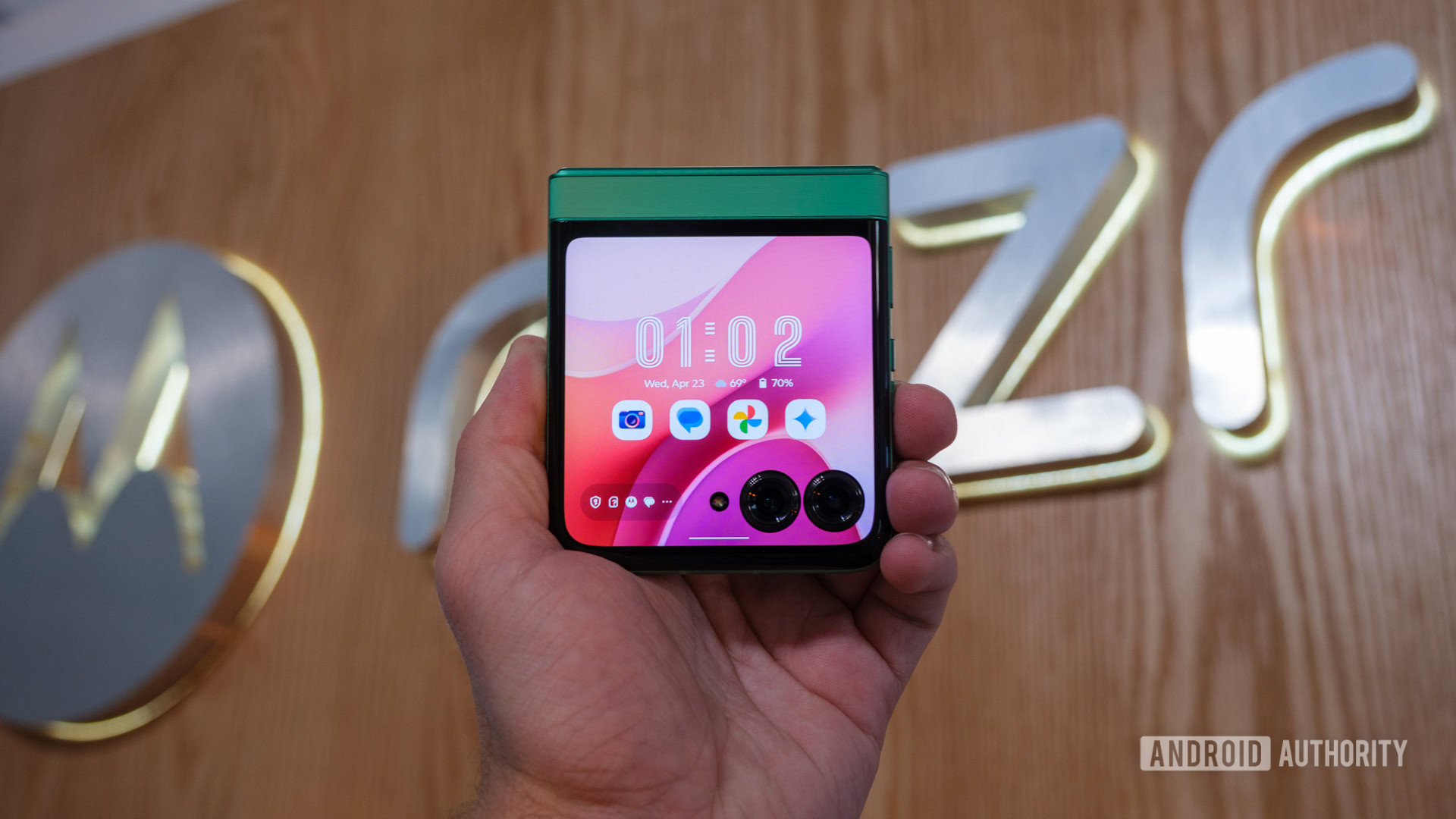 Motorola Razr 2025 held in front of logo Motorola Razr 2025 held in front of logo