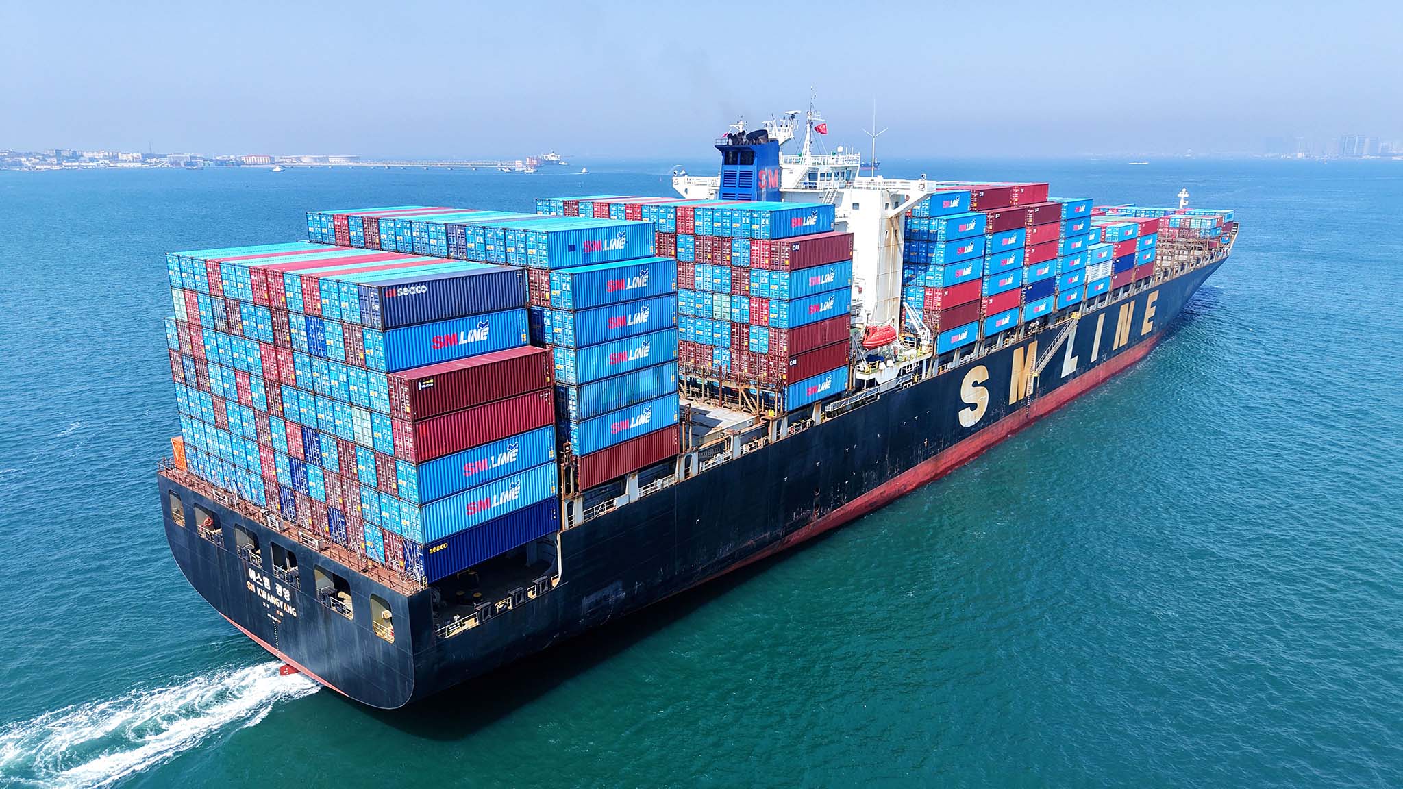A cargo ship with dozens of containers.