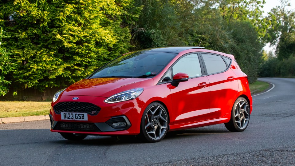 Red 2019 Ford Fiesta ST driving on a road.