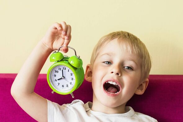 Getty generic. Child (boy) up late past his bedtime with clock