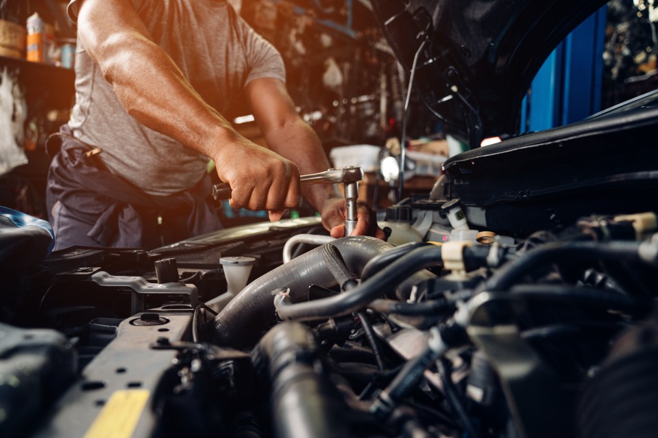 A mechanic repairing a car engine.