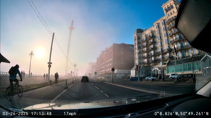 Driving along Brighton sea front in the evening, passing the Grand Hotel. Heading towards the sun and the i360, with sea fog rolling in