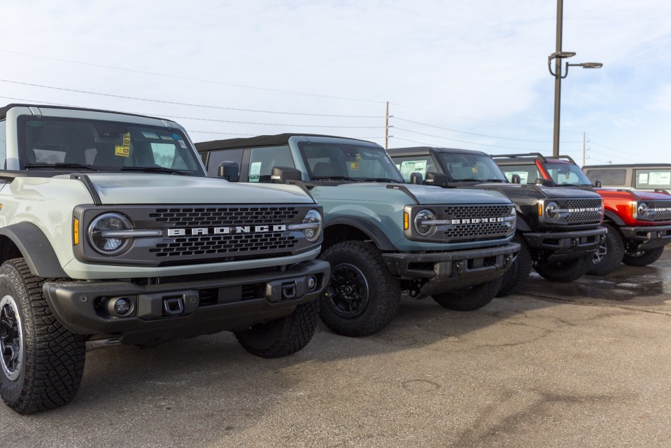 Row of pre-sold Ford Bronco SUVs at a dealership.