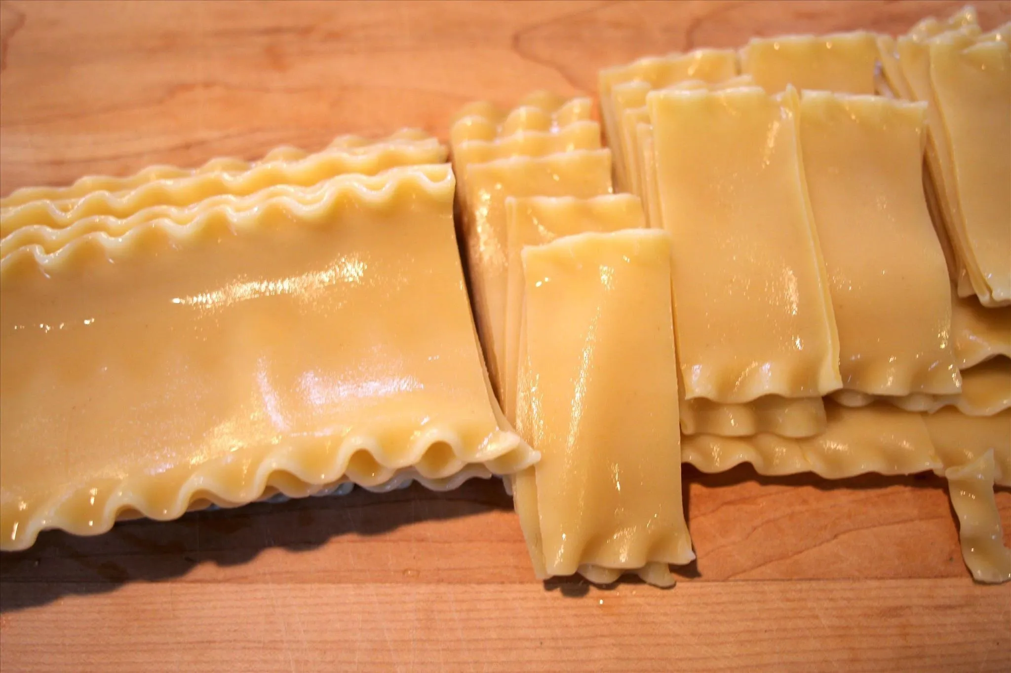 Lasagna sheets arranged on a wooden surface.