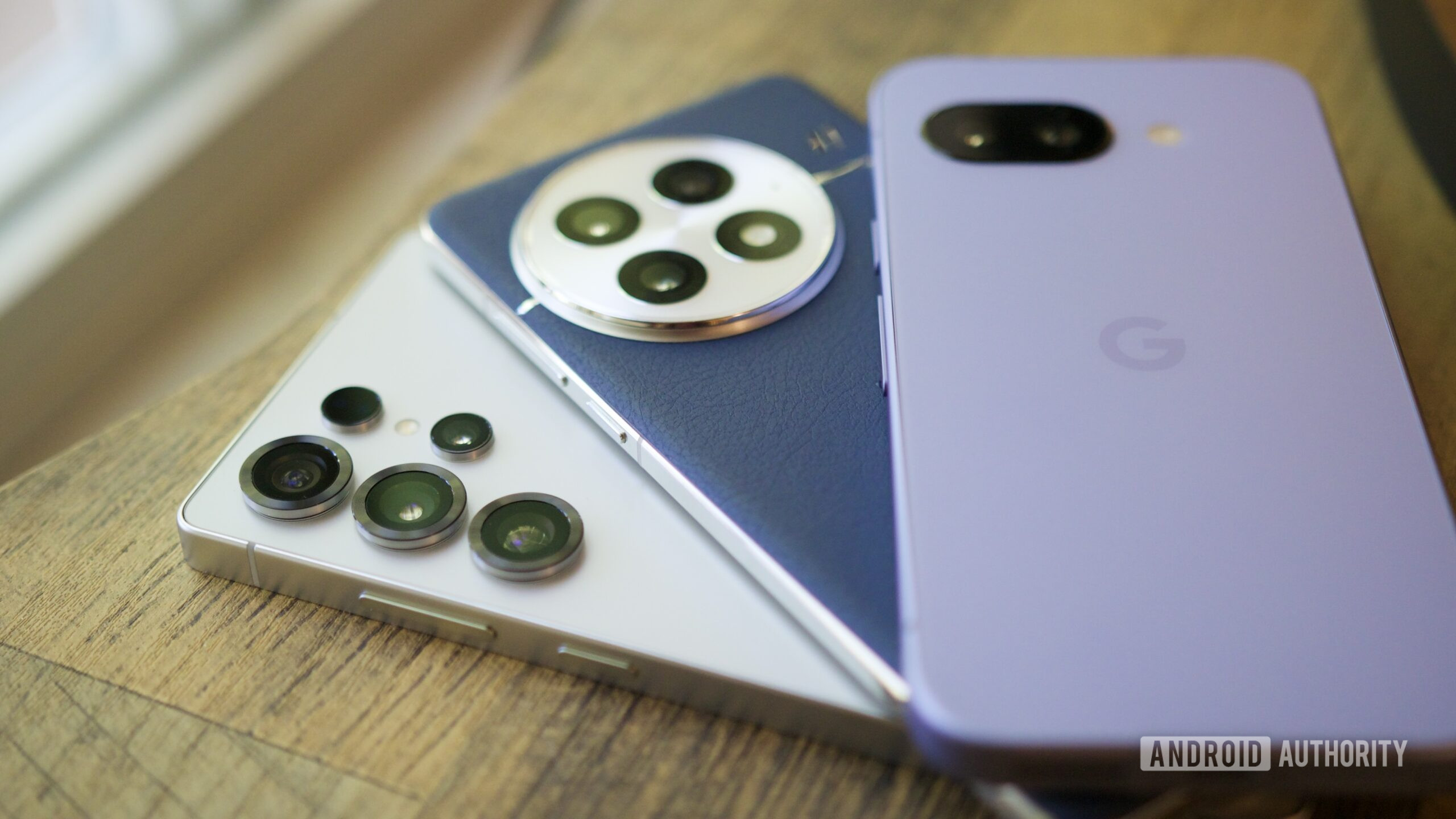 samsung galaxy s25 ultra oneplus 13 google pixel 9a hero The Samsung Galaxy S25 Ultra, OnePlus 13, and Google Pixel 9a next to each other.