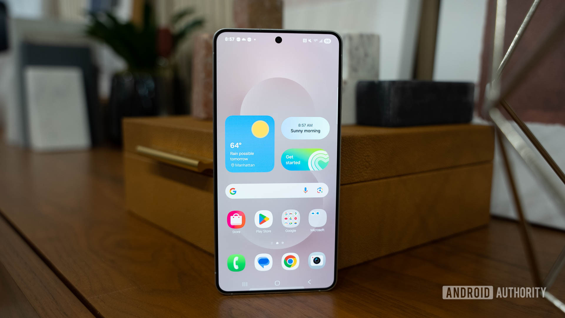 Samsung Galaxy S25 Edge Home Screen showing One Ui 7 on table propped Samsung Galaxy S25 Edge Home Screen showing One Ui 7 on table propped