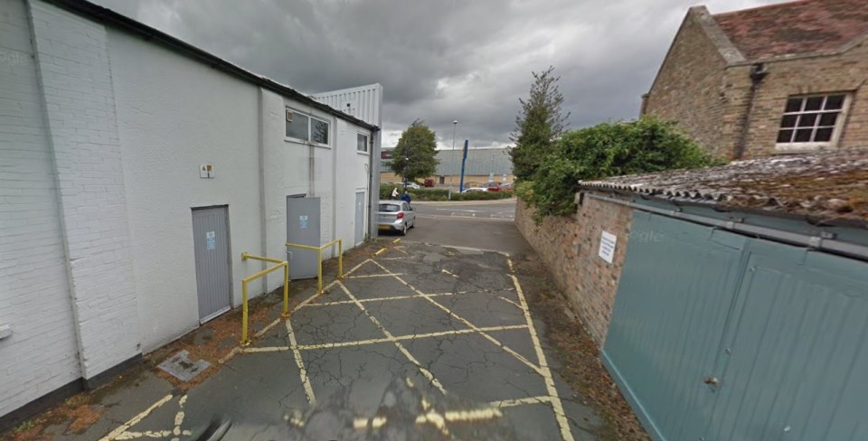 Rear view of TC Harrison Ford St Neots dealership, showing a parking area and building exterior.