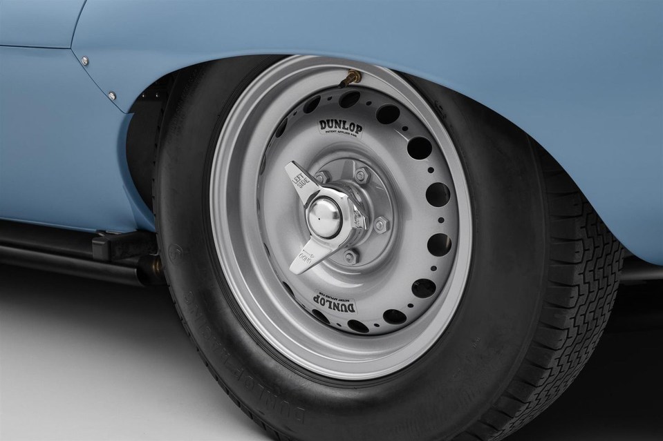 Close-up of a Dunlop tire on a pastel blue Jaguar D-Type.