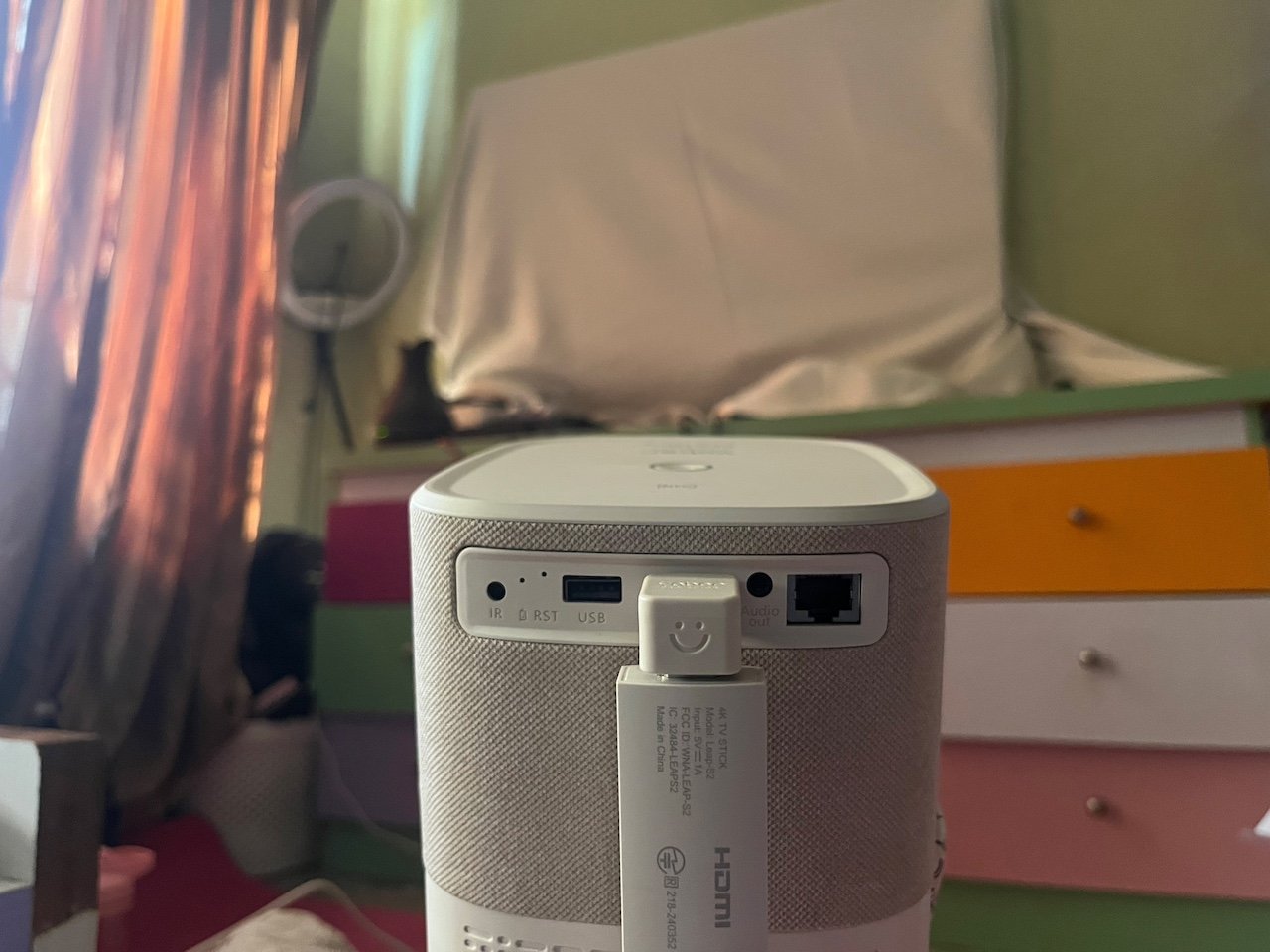 Back view of projector set against blurred colourful room background