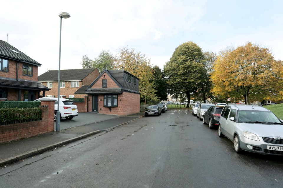 A brick garage on a residential street.