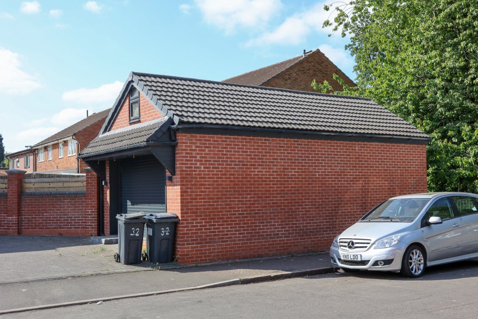 A brick garage with a black roller door.