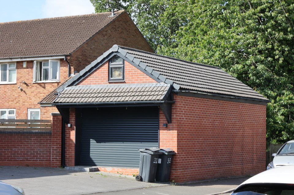 A brick garage with a dark gray roller door.