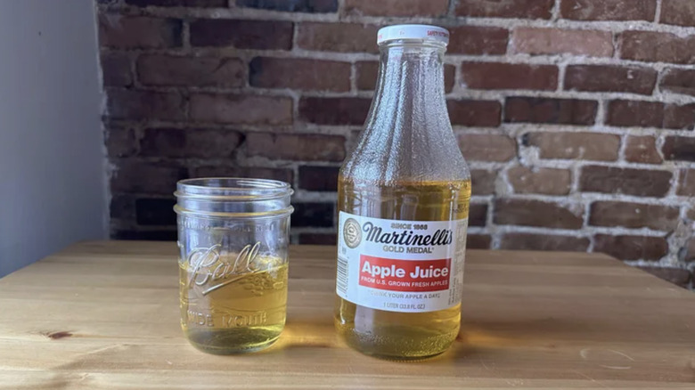 Martinelli's apple juice bottle with a glass jar filled with the juice alongside it