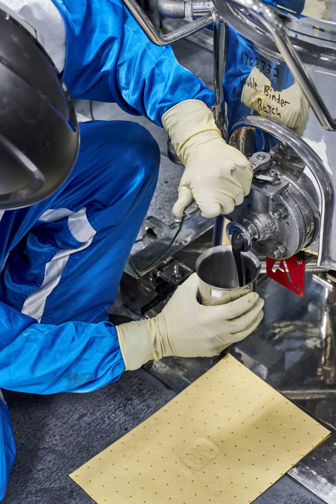 A battery technician at the General Motors Wallace Battery Cell Innovation Center takes a chemistry slurry sample.