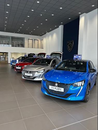 Several Peugeot cars in a showroom.