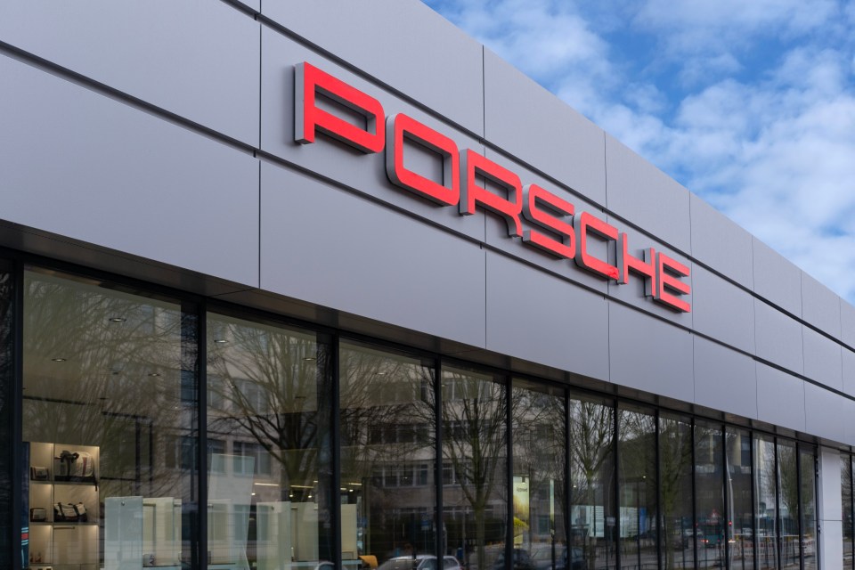 Porsche dealership exterior with red logo.
