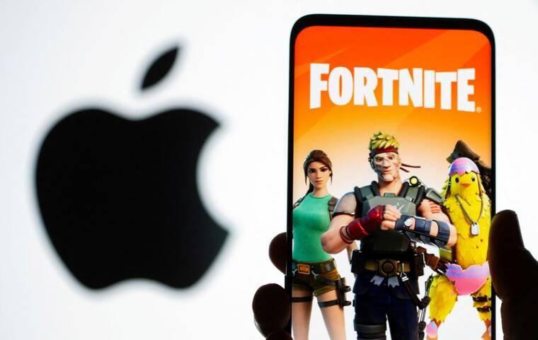 REUTERS/DADO RUVIC/ILLUSTRATION/FILE PHOTO
A Fortnite game graphic is displayed on a smartphone in front of the Apple logo in this illustration in May 2021. Epic Games Fortnite video game was not available on Apples iPhone devices in the European Union and the United States on Friday.
