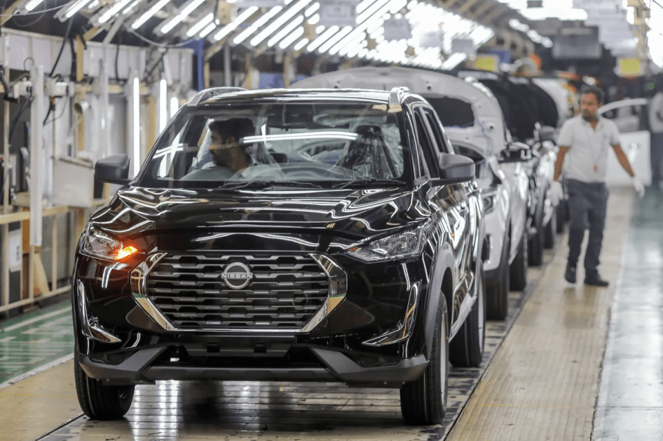 Black Nissan SUV on assembly line.