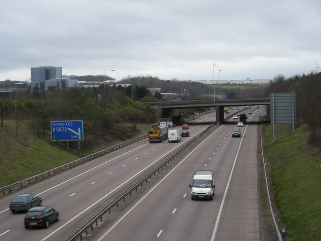Multi-lane highway with traffic and an overpass.
