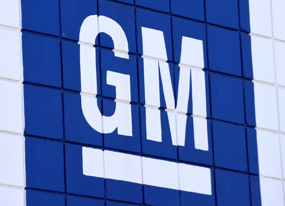 GM logo on a blue and white brick wall.