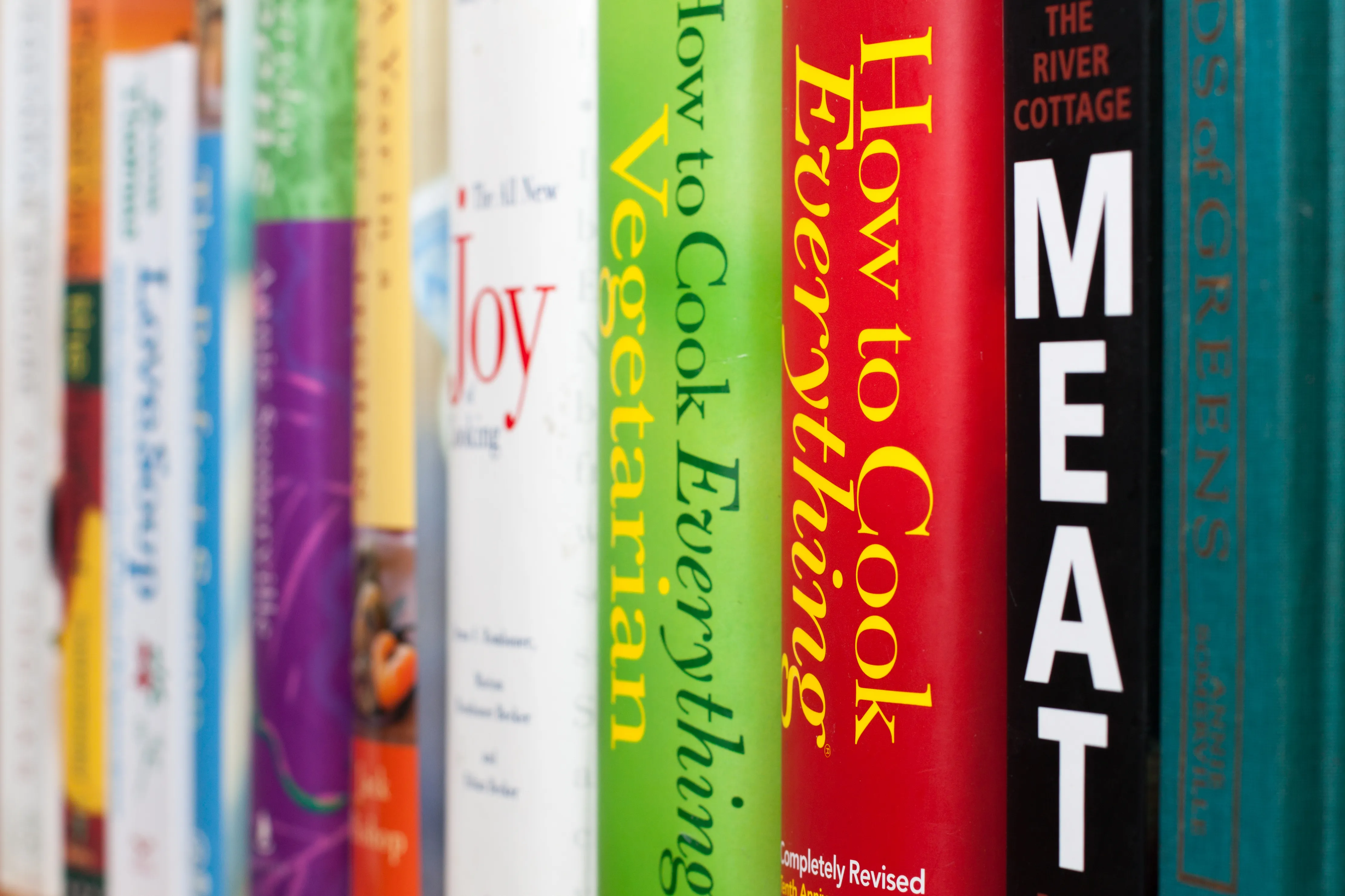 null A close-up view of cookbooks on a shelf.