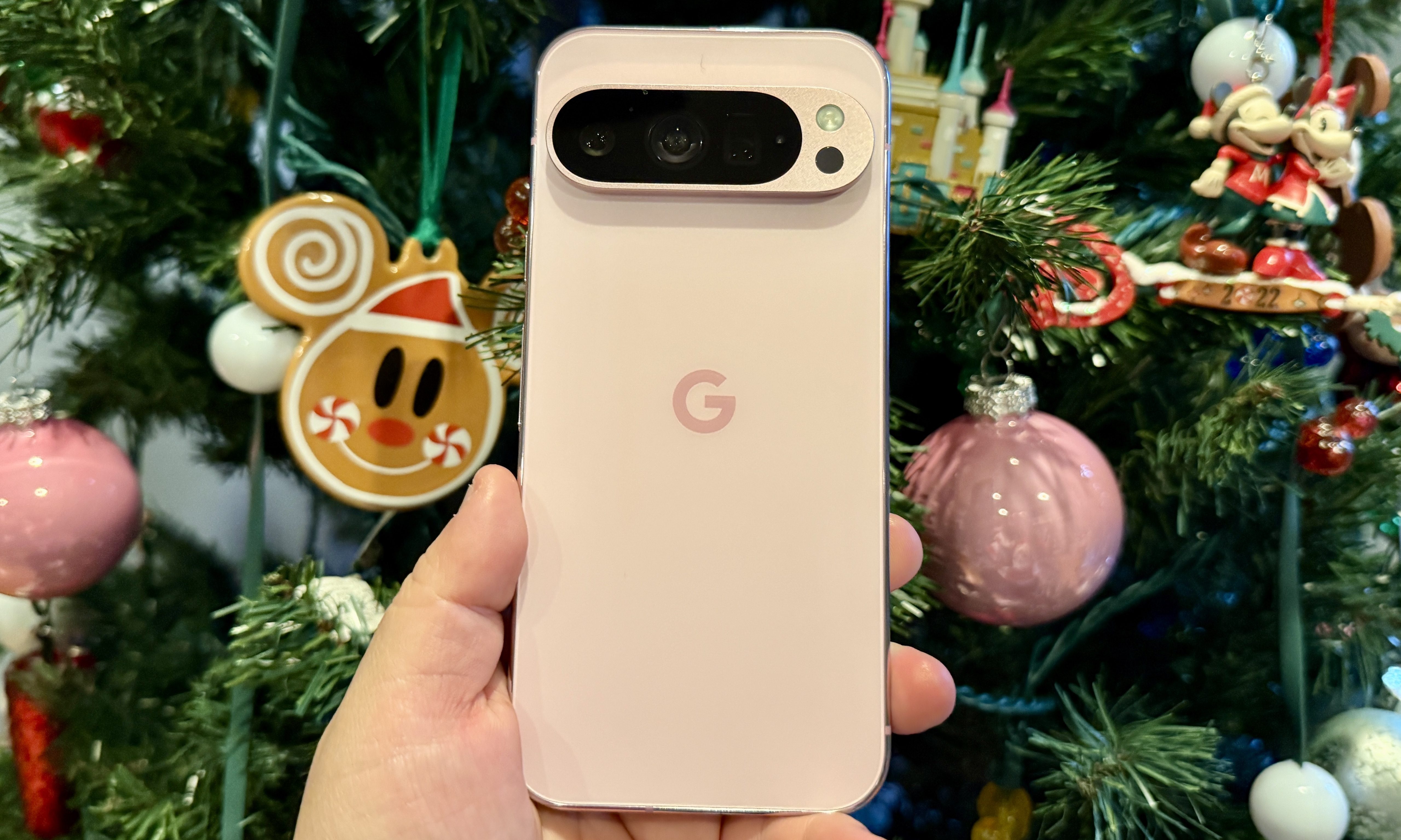 Rose Quartz Pixel 9 Pro in front of a Christmas tree.