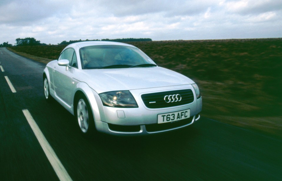 Silver Audi TT quattro driving on a road.