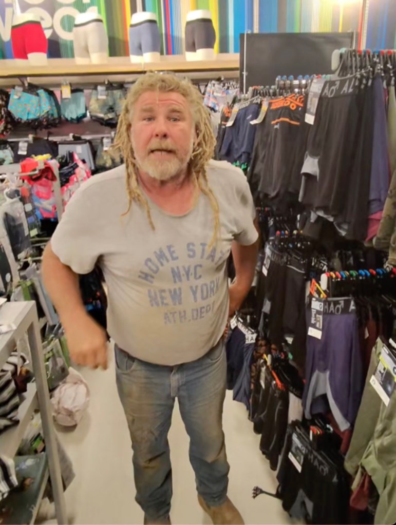 Young man in Adelaide filming a prank in a Kmart store, where he pretends to tap an older man's phone to use Apple Pay