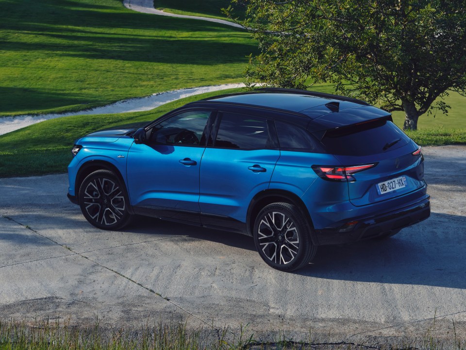 Blue Renault Austral parked on a golf course.
