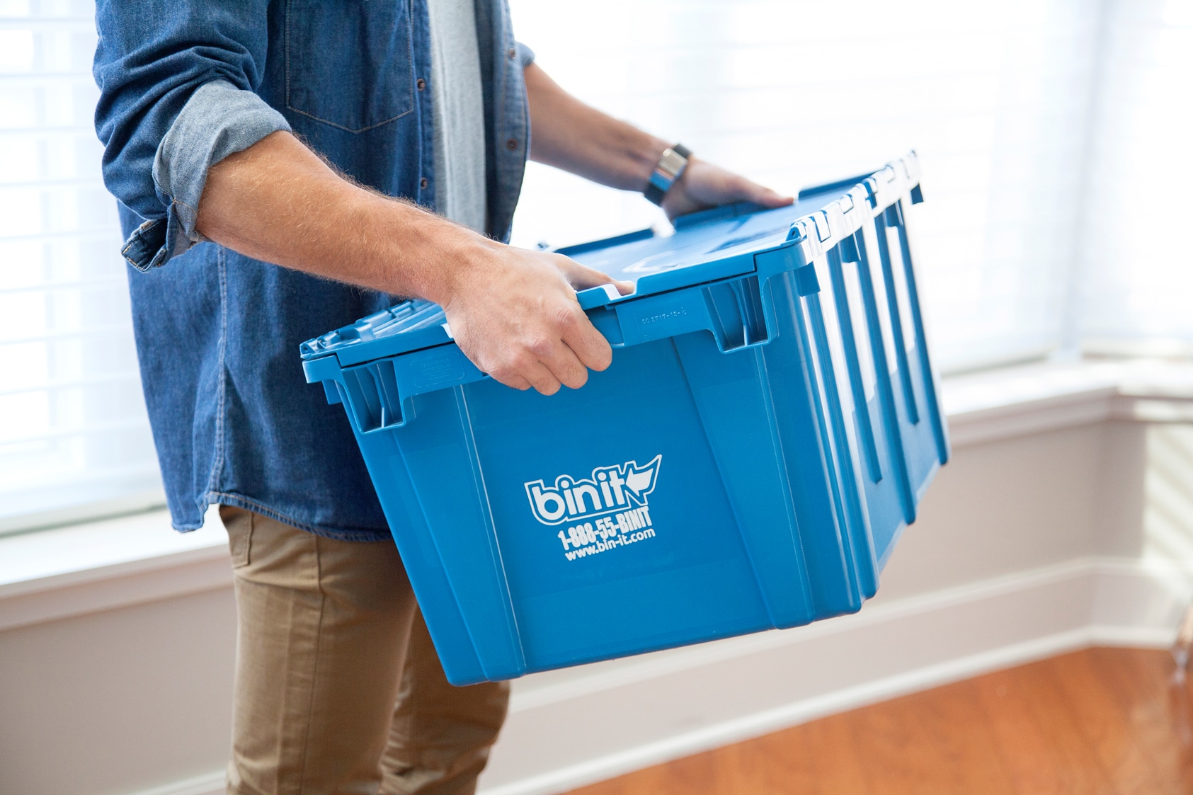 Person holding a plastic moving bin.