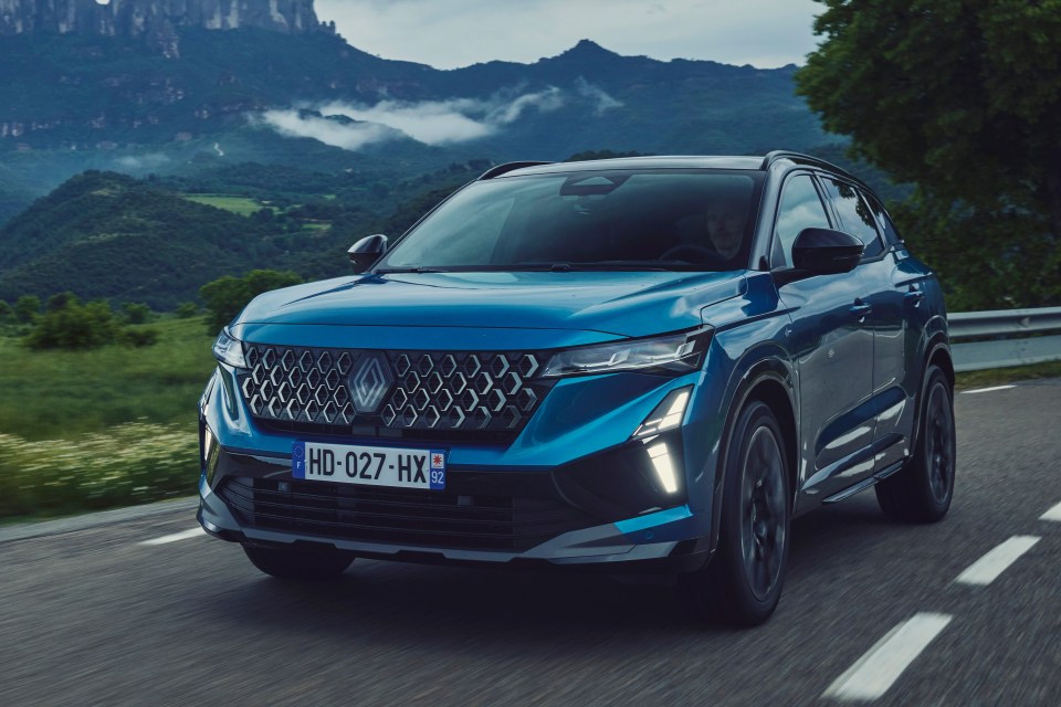 Blue Renault Austral driving on a mountain road.