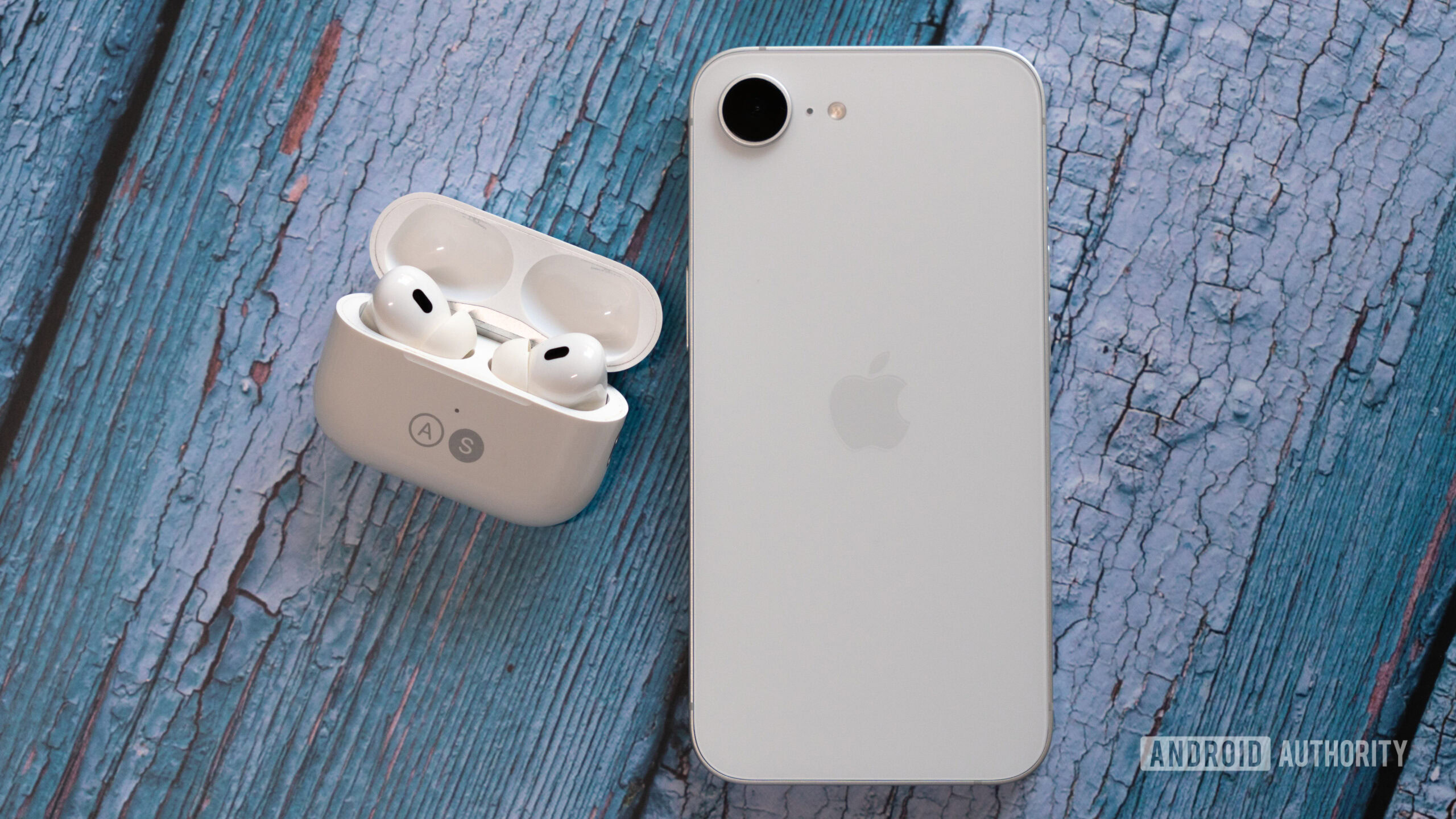 Apple iPhone 16e besides AirPods Pro 2 Apple iPhone 16e besides AirPods Pro 2