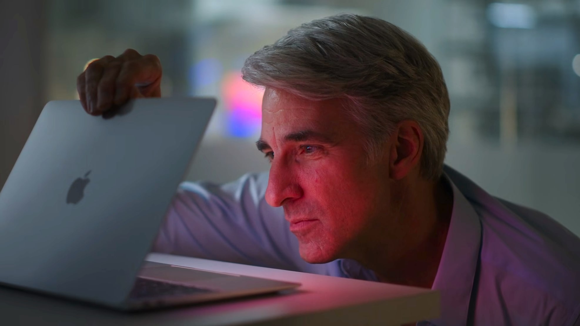 Apple's Craig Federighi opens a MacBook Air laptop at an Apple launch event.